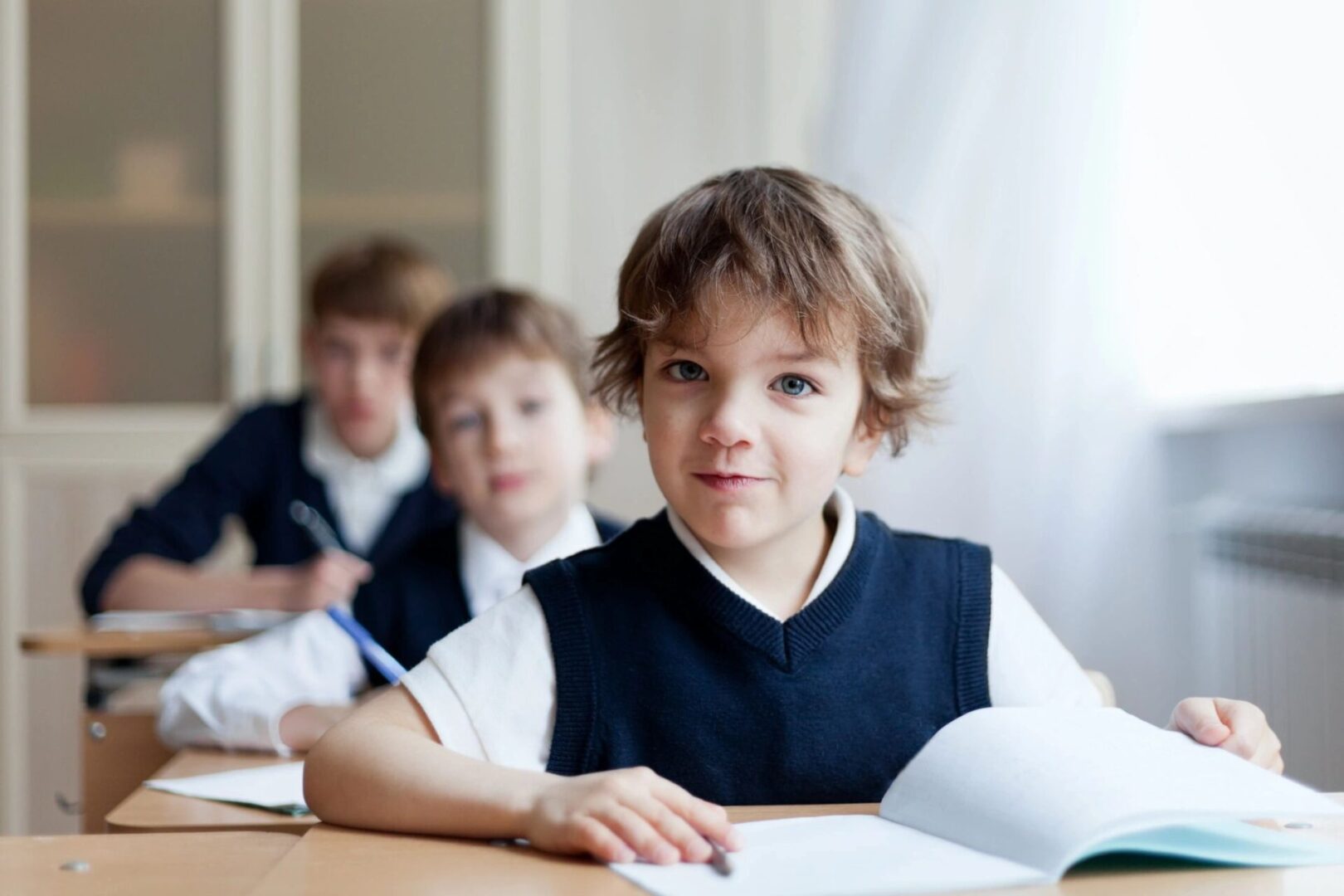 A group of children sitting at a table with papers.