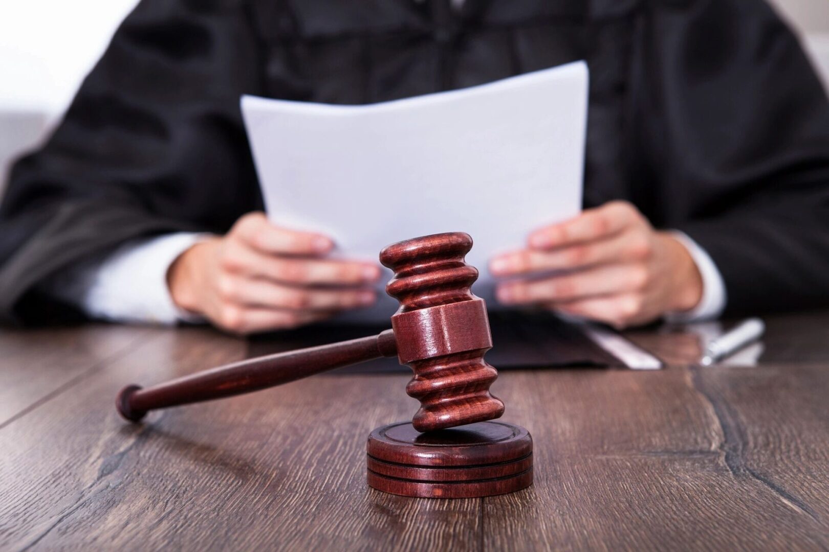 A judge 's gavel sitting on top of a wooden table.